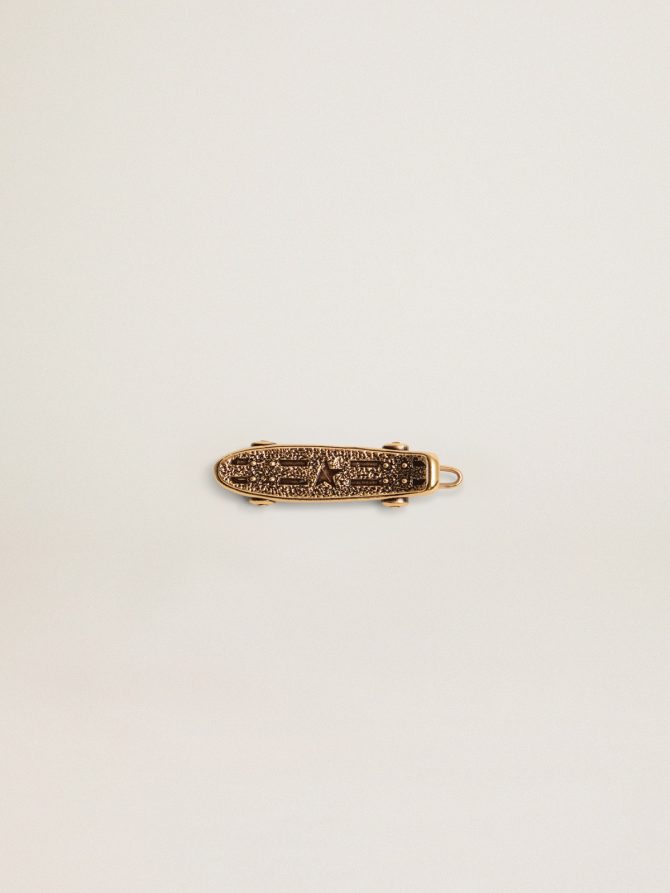 Men’s lace accessory in old gold color in the shape of a skateboard